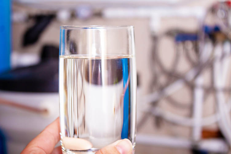 Clean water glass in hand. Water softening.